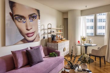 a living room with a couch and a poster on the wall