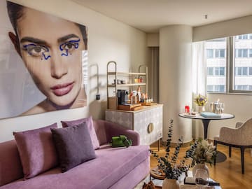 a living room with a couch and a poster on the wall