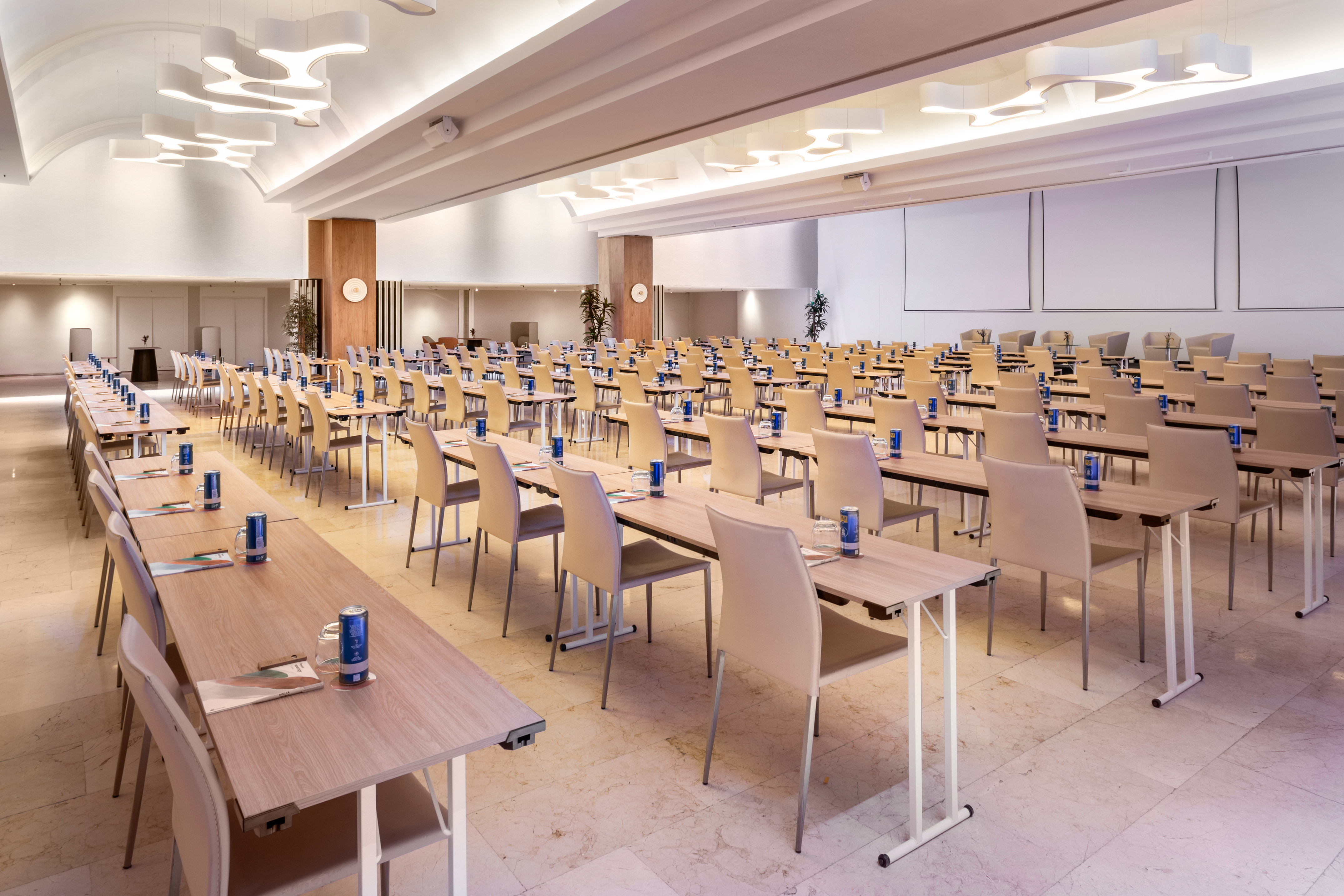 Modern conference room with classroom setup, elegant tables and lighting.