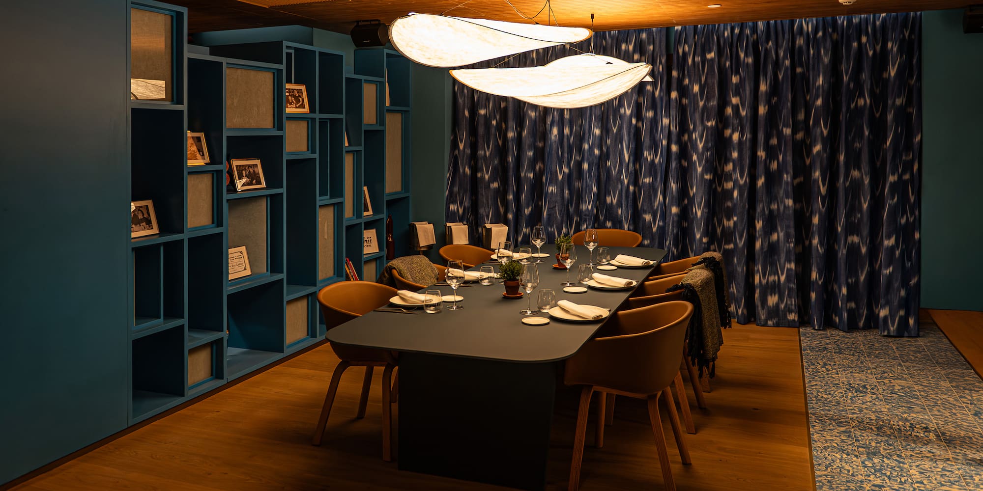 Modern private dining room, elegant table setting, unique lights, teal decor.