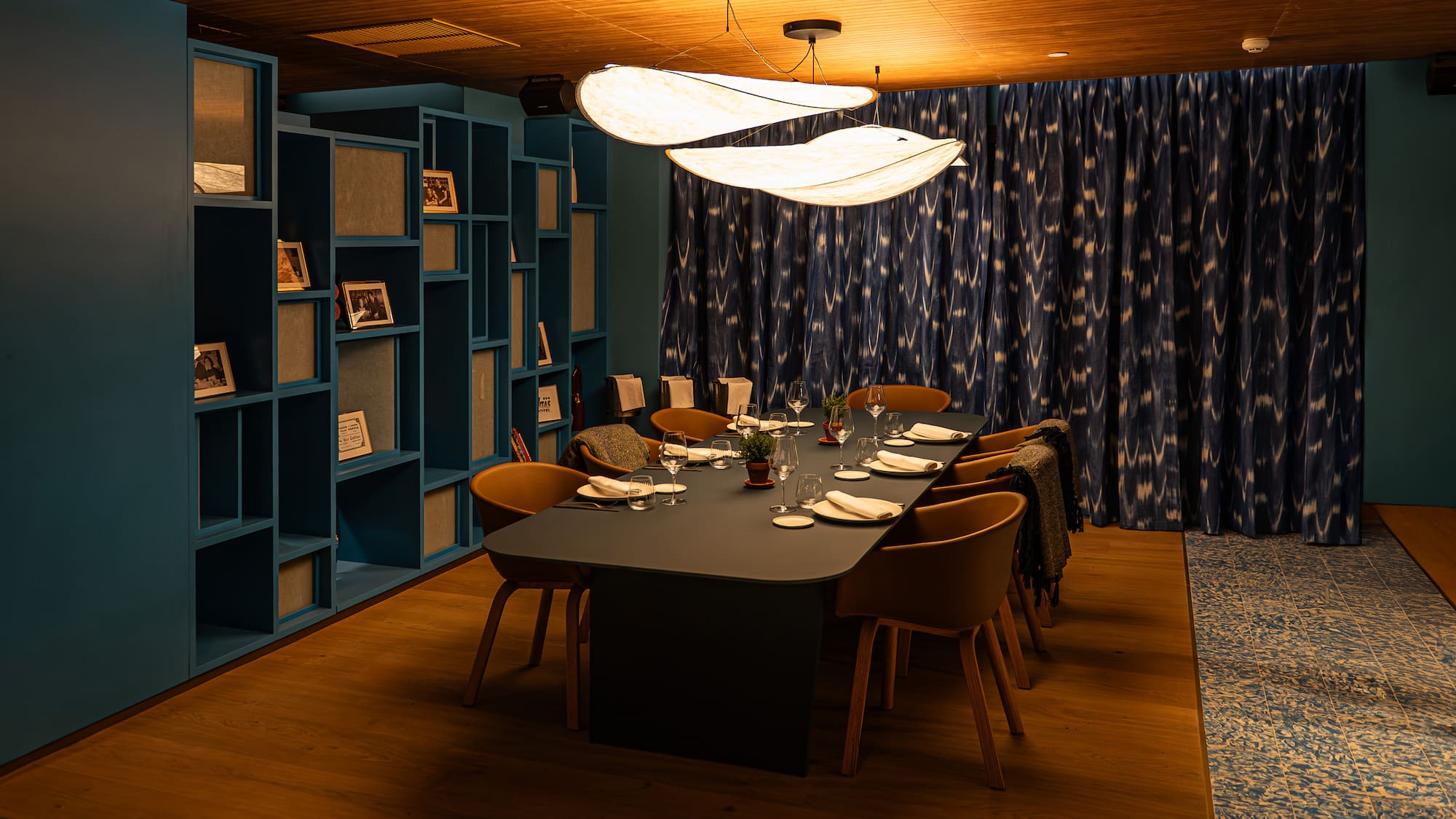 Modern private dining room, elegant table setting, unique lights, teal decor.