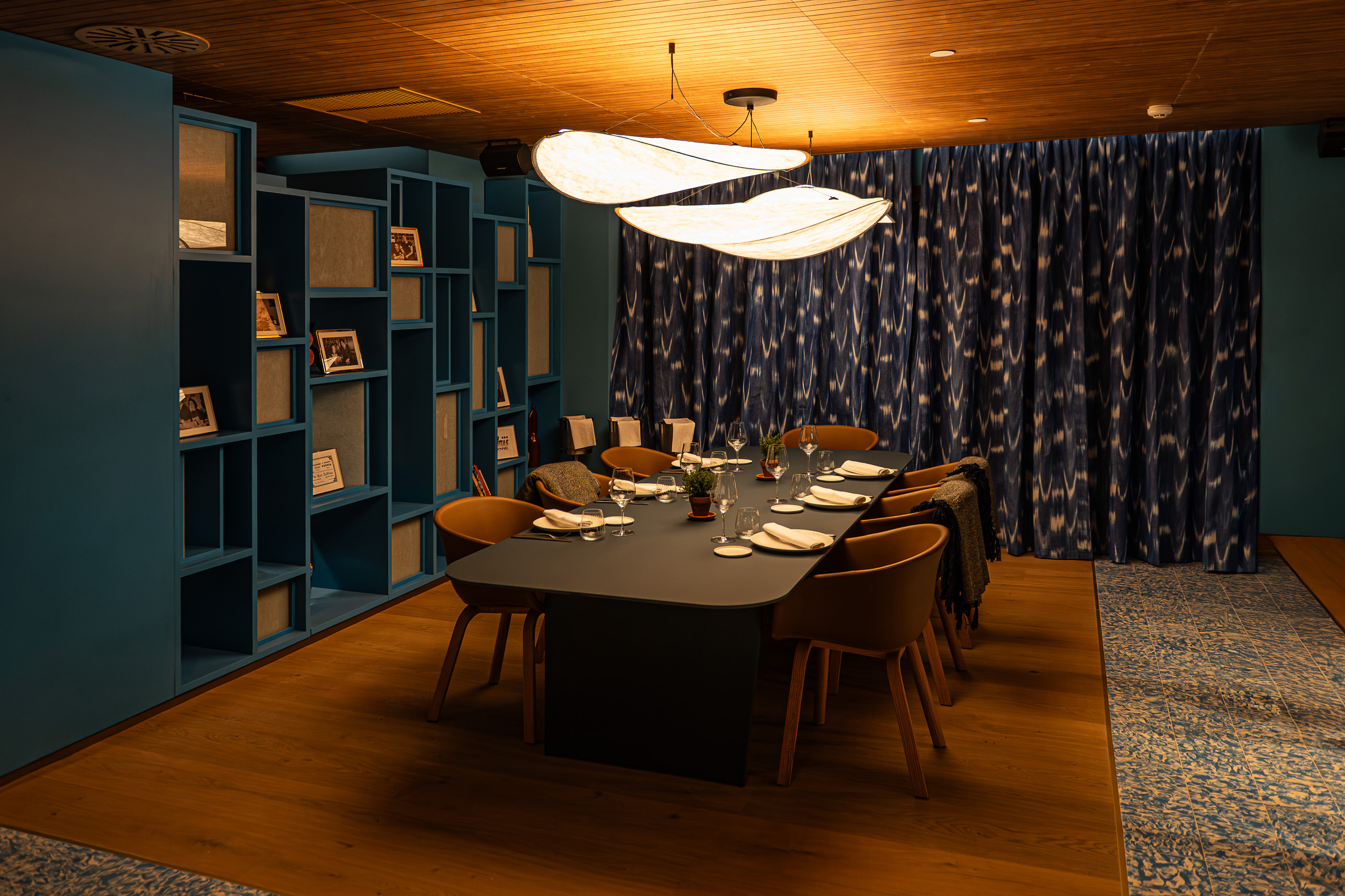 Modern private dining room, elegant table setting, unique lights, teal decor.