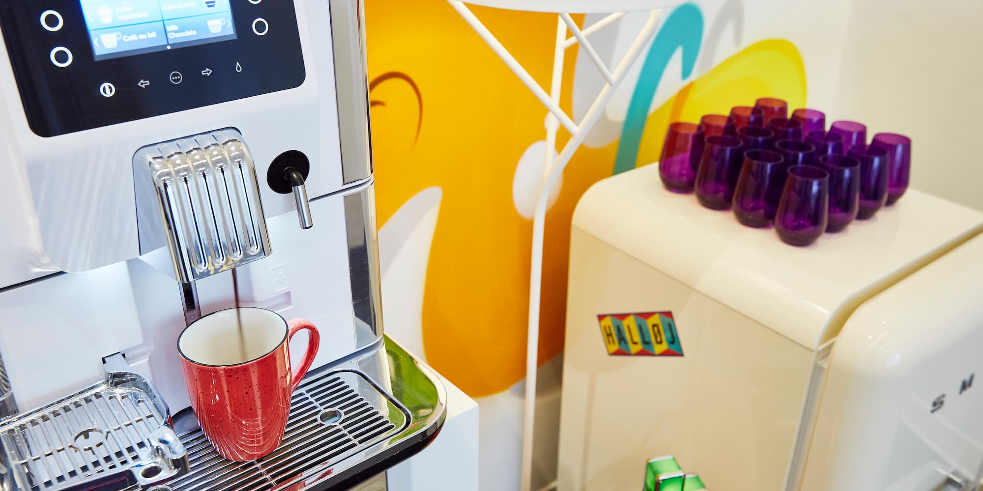 a coffee machine with a red cup on a shelf