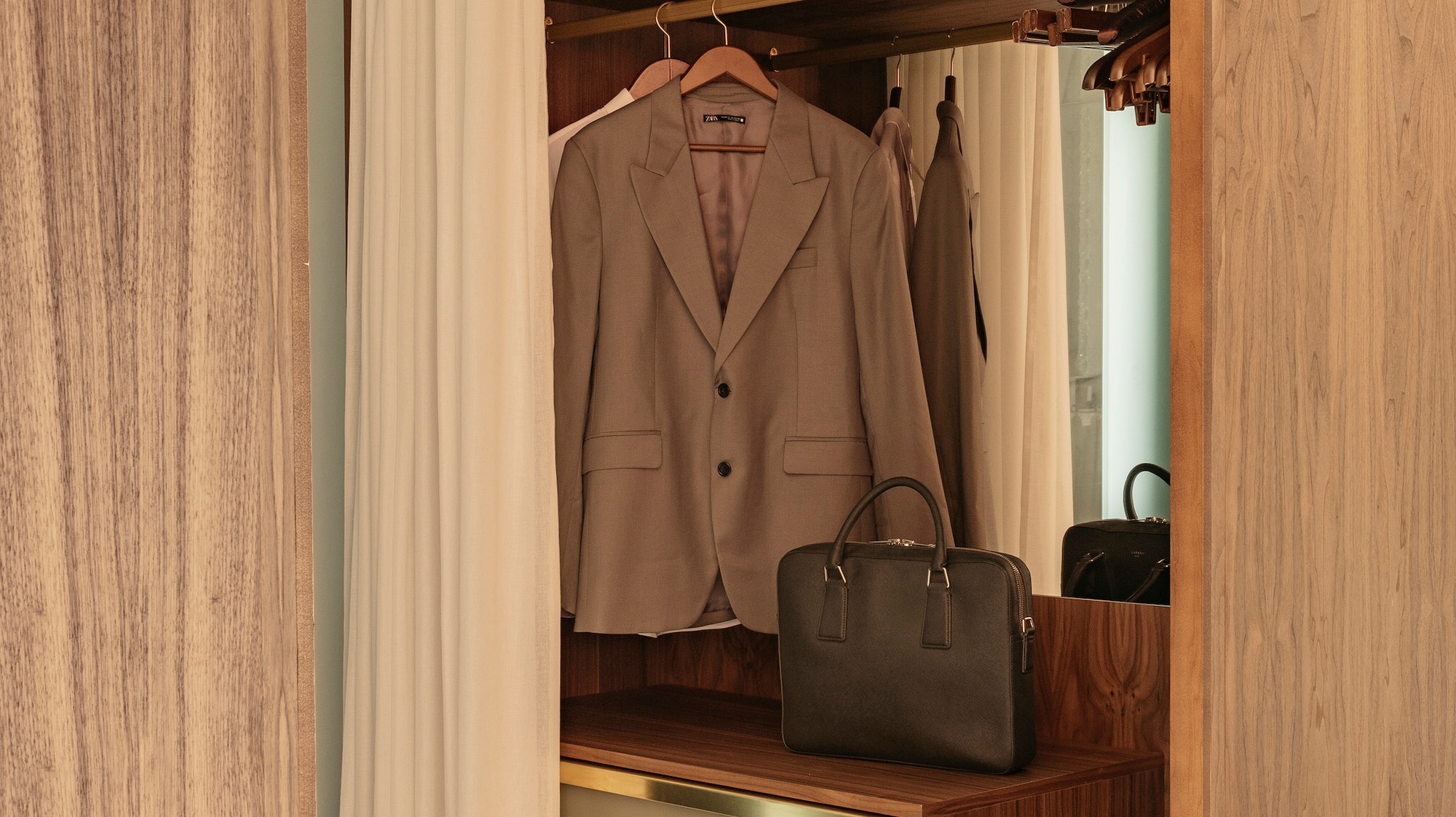 a closet with a jacket and a purse
