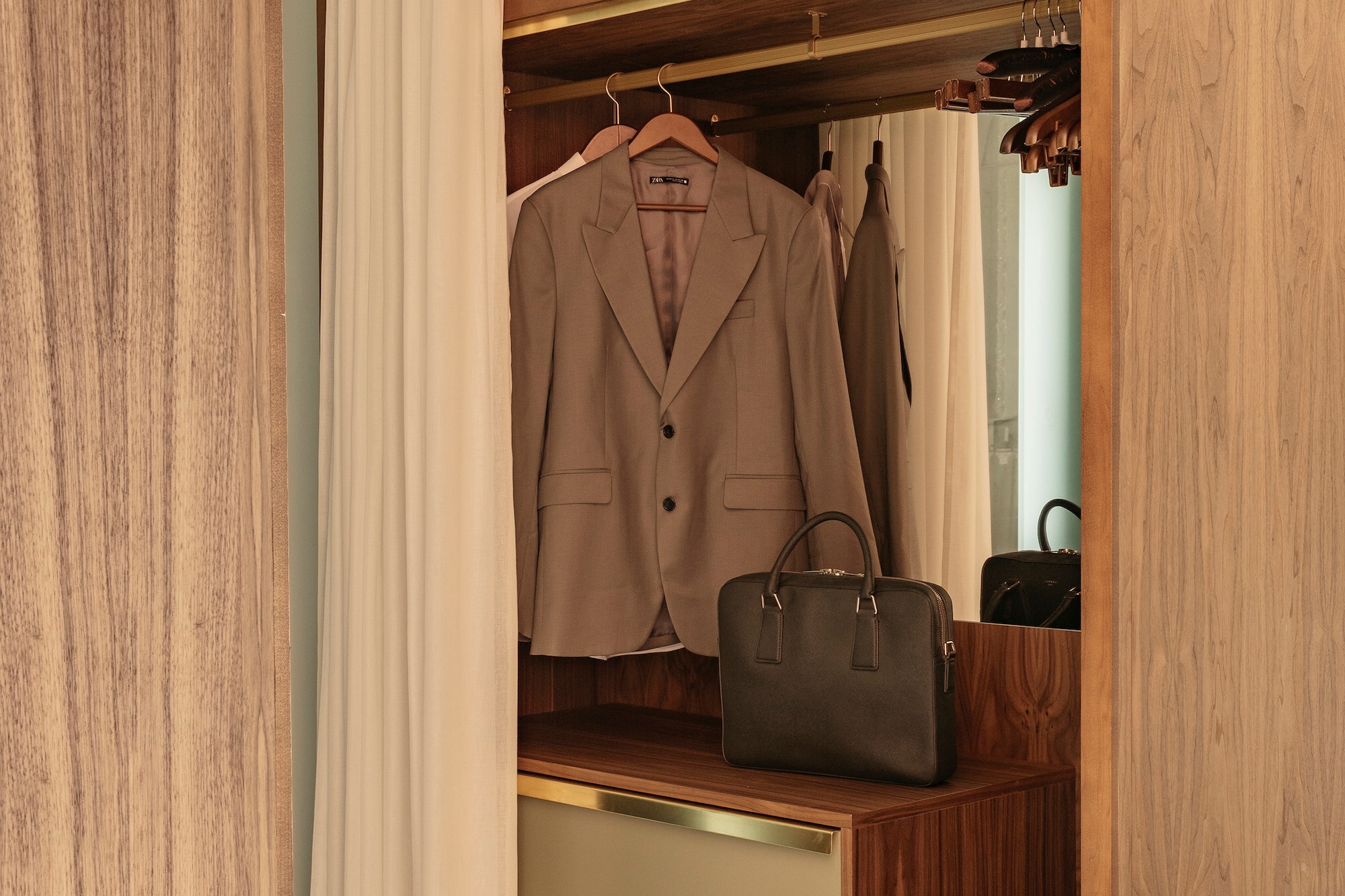 a closet with a jacket and a purse