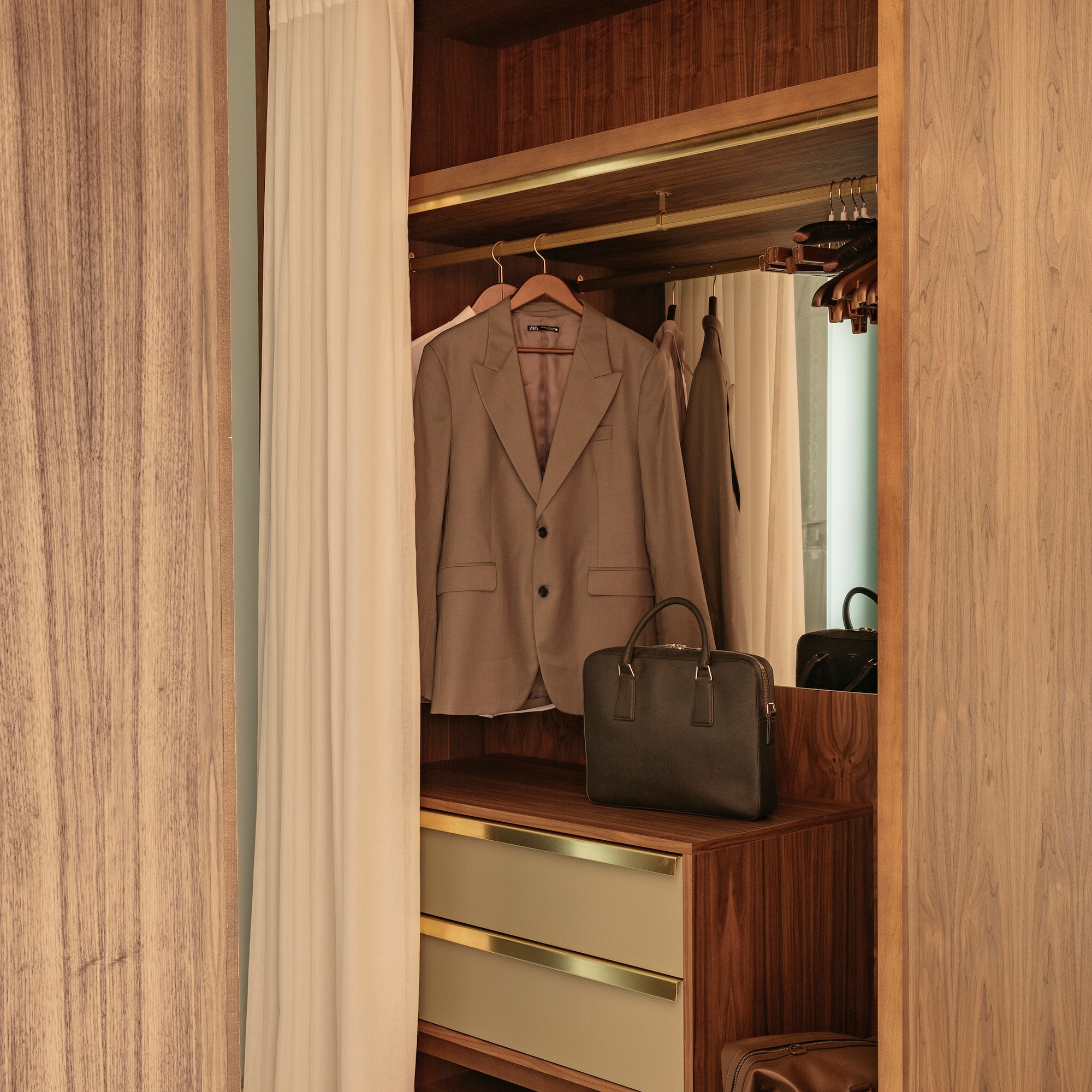 a closet with a jacket and a purse