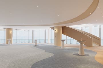 a large room with a staircase and tables