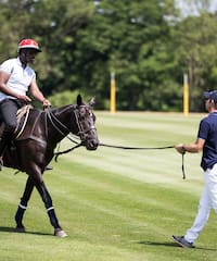 a man on a horse pulling another man on a leash