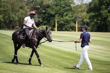 a man on a horse pulling another man on a leash