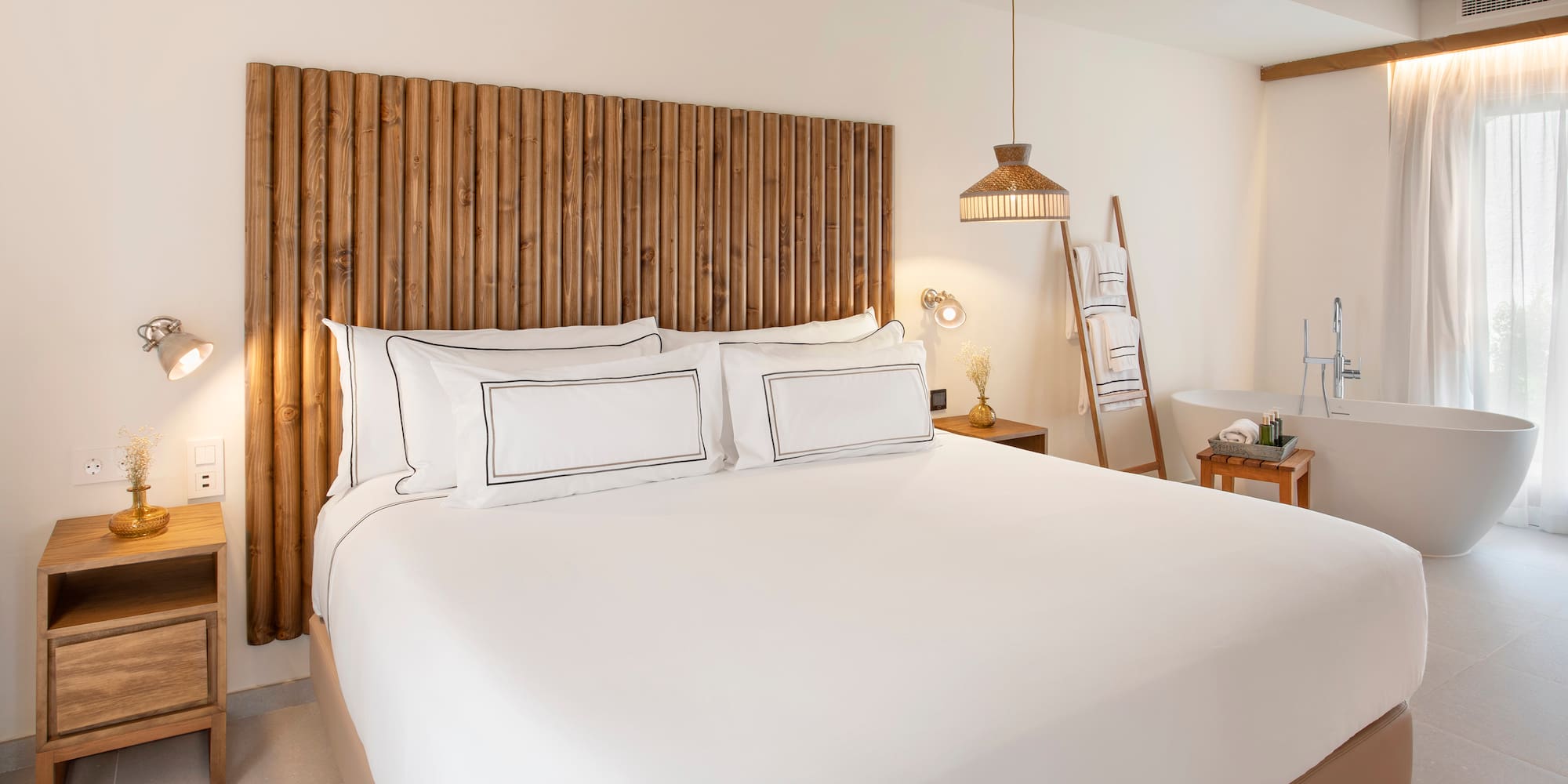 a bed with white sheets and a wooden headboard