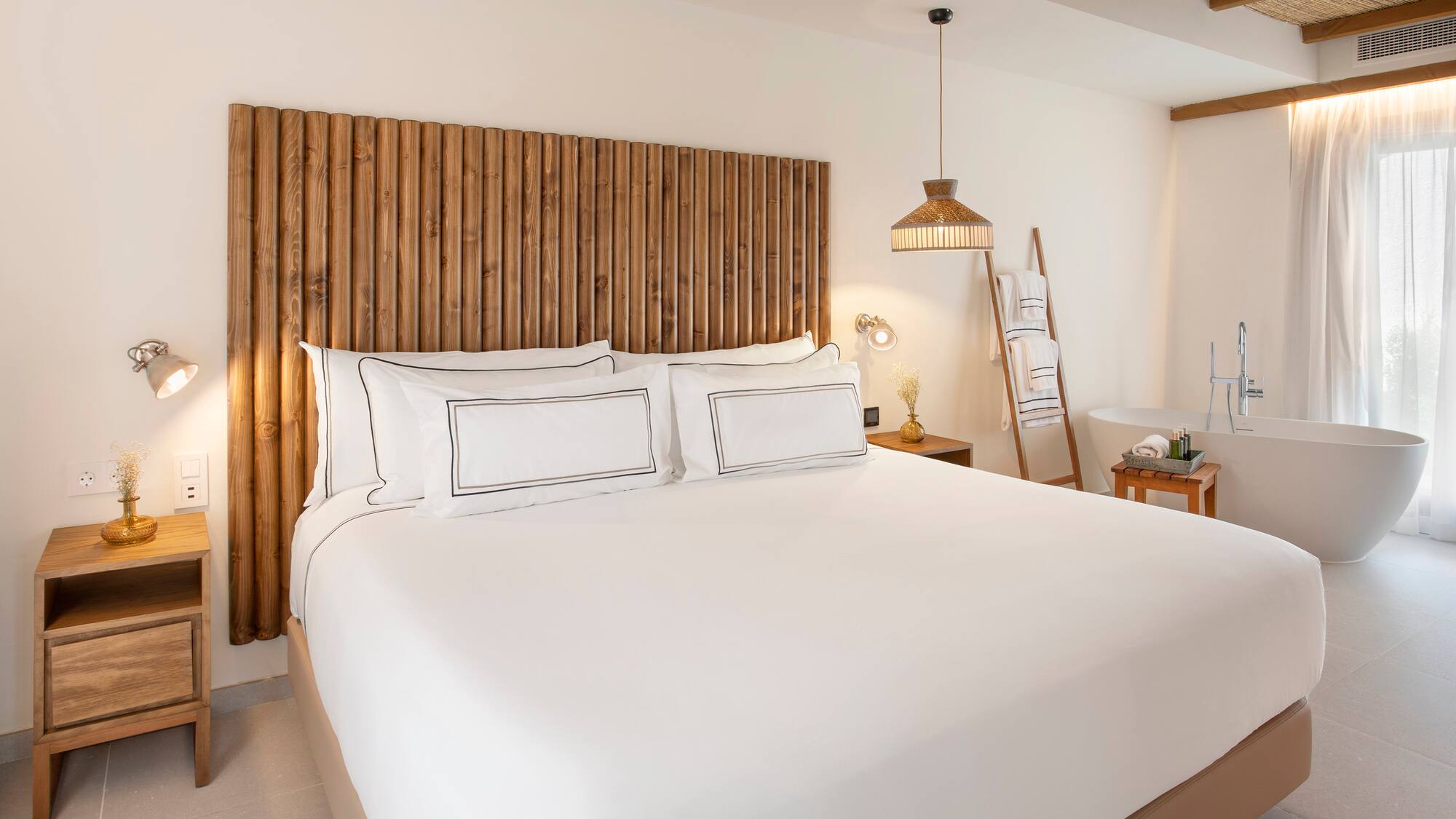 a bed with white sheets and a wooden headboard