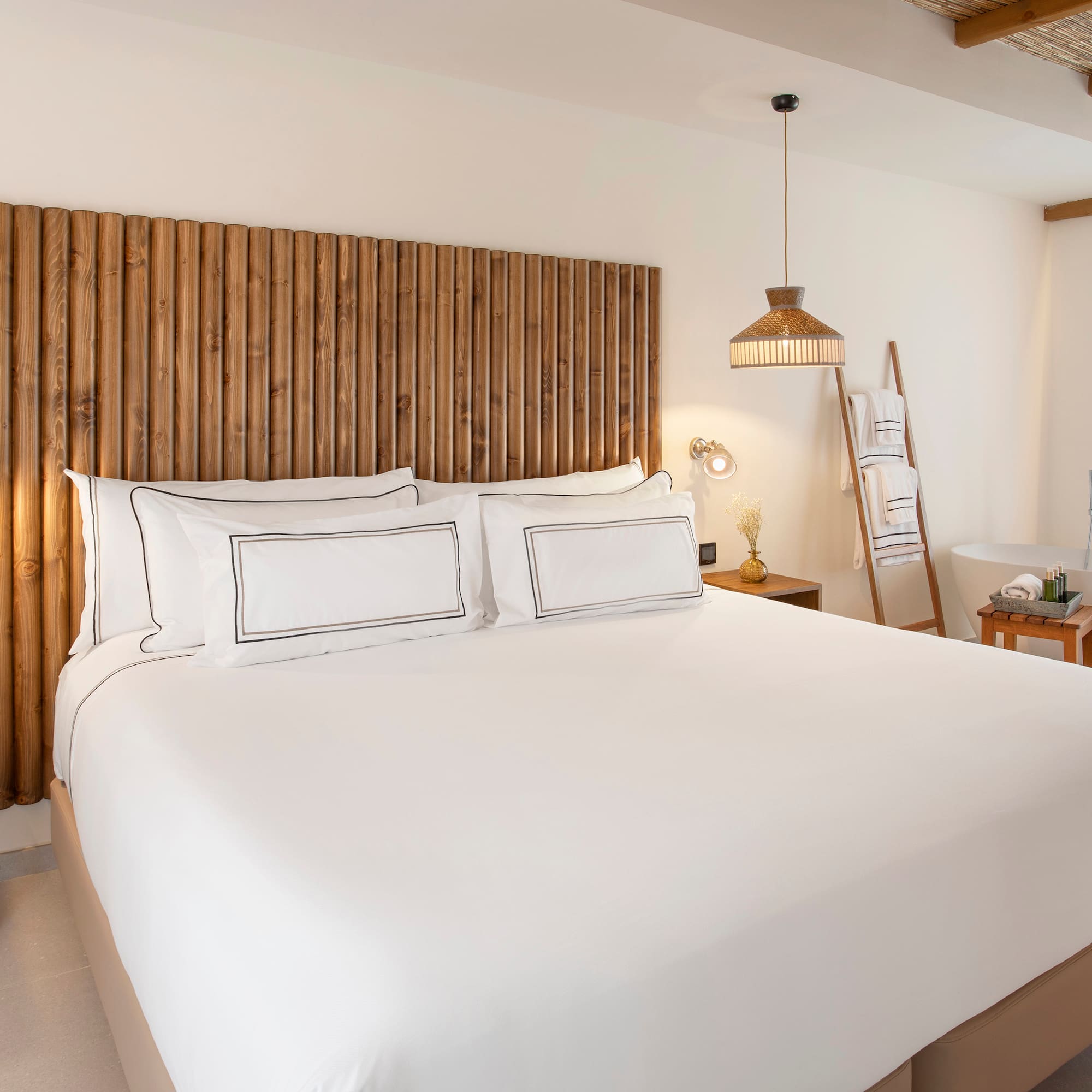 a bed with white sheets and a wooden headboard