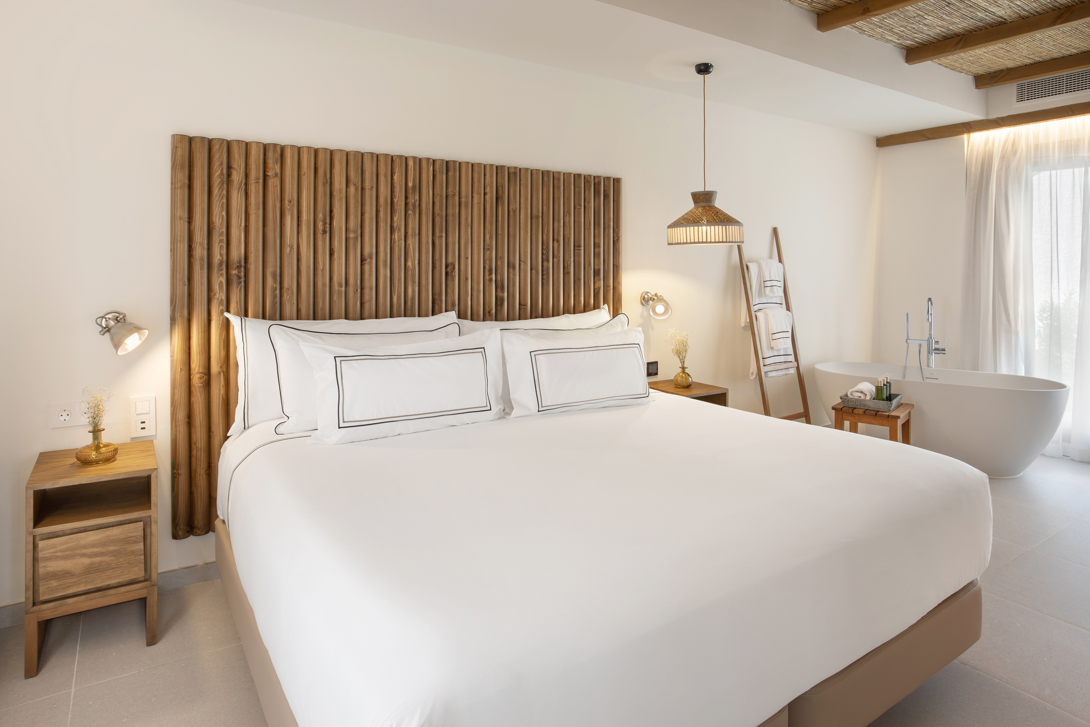 a bed with white sheets and a wooden headboard