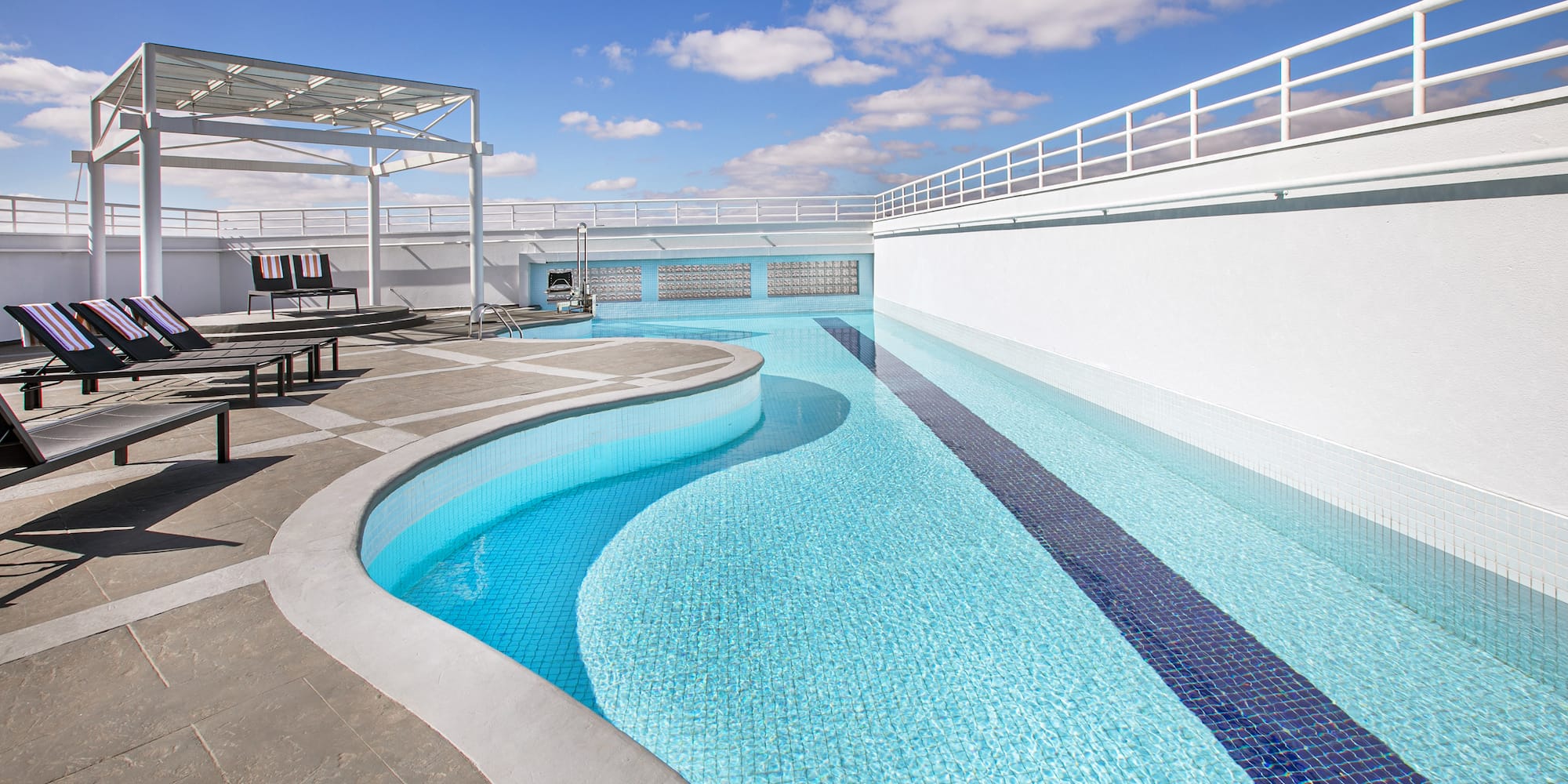 a swimming pool with a deck and chairs