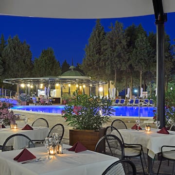 a restaurant with tables and chairs and a pool