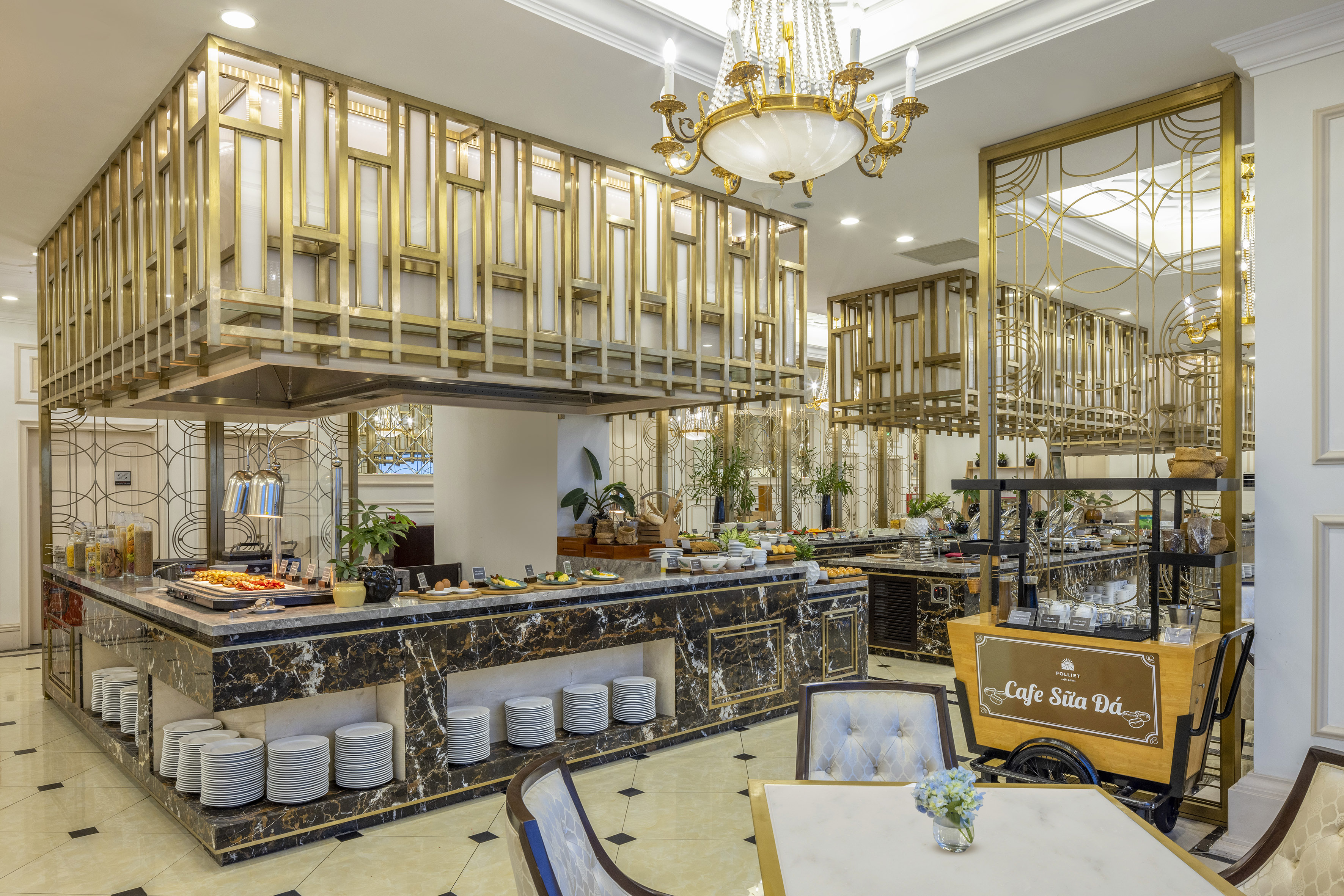 Luxury hotel breakfast buffet with elegant gold decor and marble counters.
