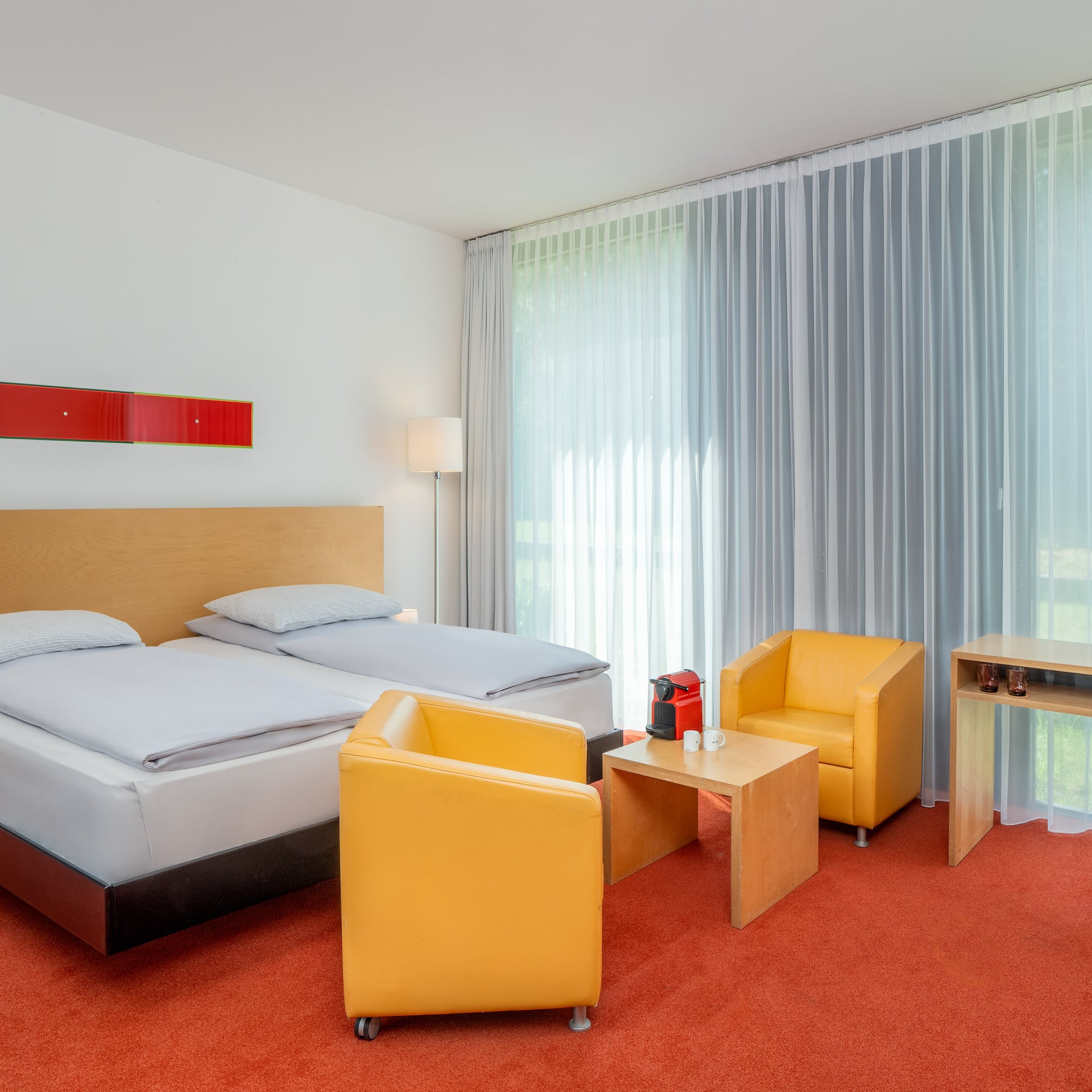 a room with two beds and a table and chairs