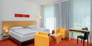 a room with two beds and a table and chairs