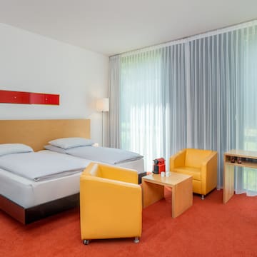 a room with two beds and a table and chairs