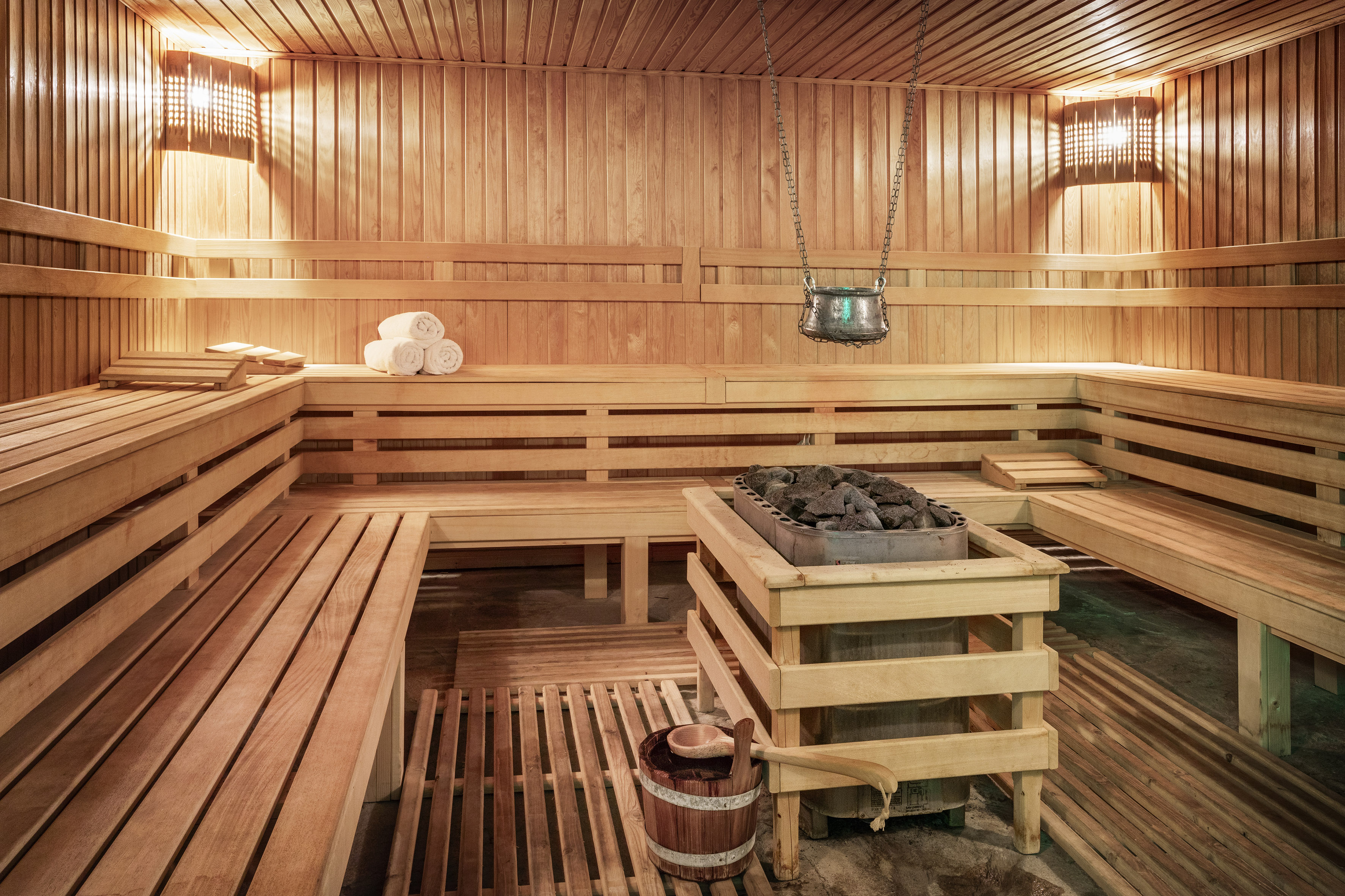 a sauna with wood walls and a bucket of charcoal