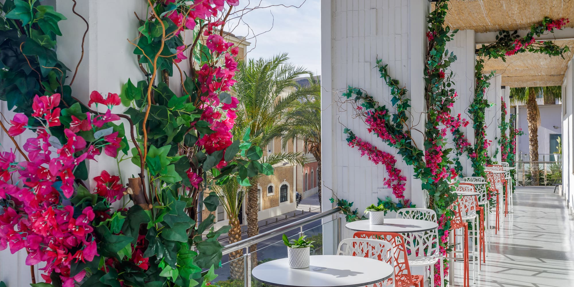 a white tables and chairs with pink flowers on a white wall