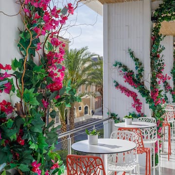 a white tables and chairs with pink flowers on a white wall