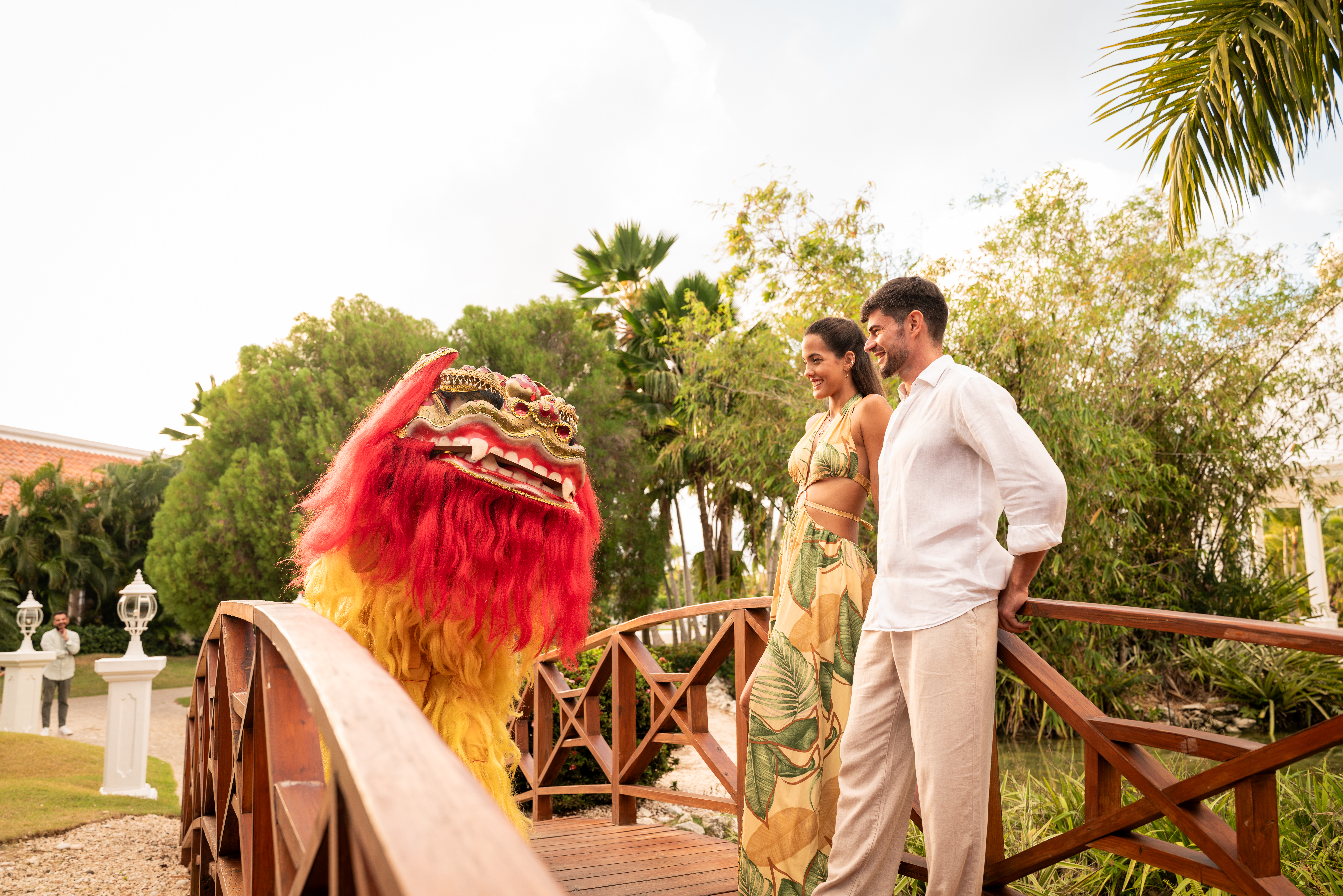 a man and woman standing on a bridge with a lion garment
