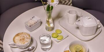 a table with a cup of tea and a vase of flowers