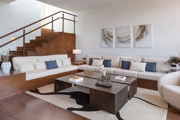 a living room with a staircase and couches