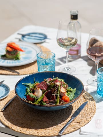 a bowl of salad and glasses of wine