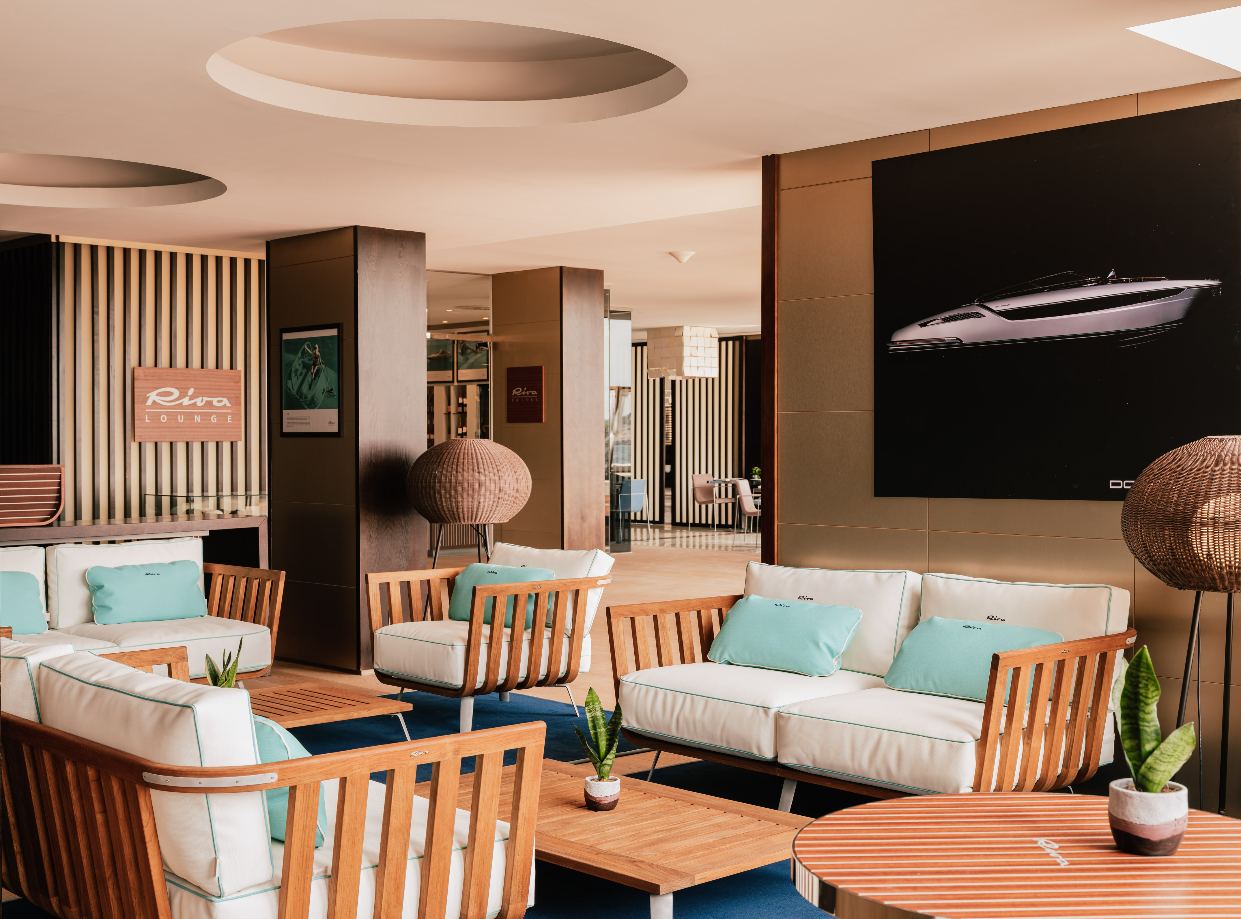 Riva Lounge interior with modern wooden seating, blue accents, and yacht art.