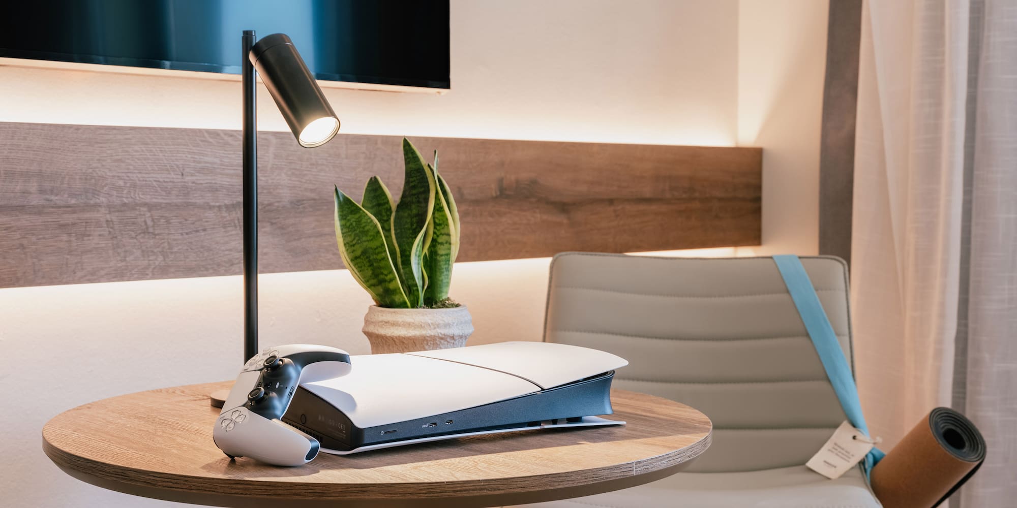 เครื่องเล่นเกม PlayStation 5 บนโต๊ะไม้กลมในห้องพักโรงแรม - The Townhouse พร้อมวิวเมือง - INNSiDE Palma Avenidas, ปัลมาเดมายอร์กา