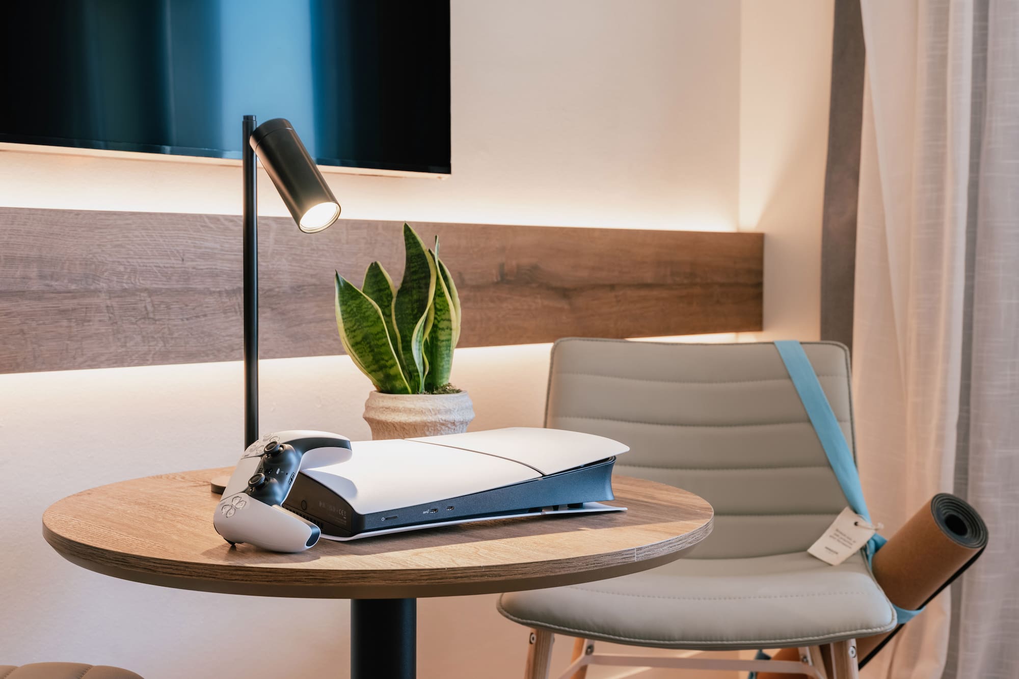 เครื่องเล่นเกม PlayStation 5 บนโต๊ะไม้กลมในห้องพักโรงแรม - The Townhouse พร้อมวิวเมือง - INNSiDE Palma Avenidas, ปัลมาเดมายอร์กา