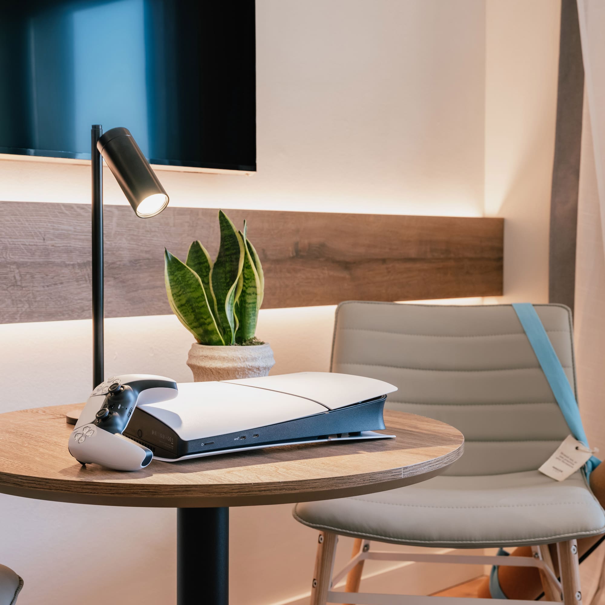 เครื่องเล่นเกม PlayStation 5 บนโต๊ะไม้กลมในห้องพักโรงแรม - The Townhouse พร้อมวิวเมือง - INNSiDE Palma Avenidas, ปัลมาเดมายอร์กา