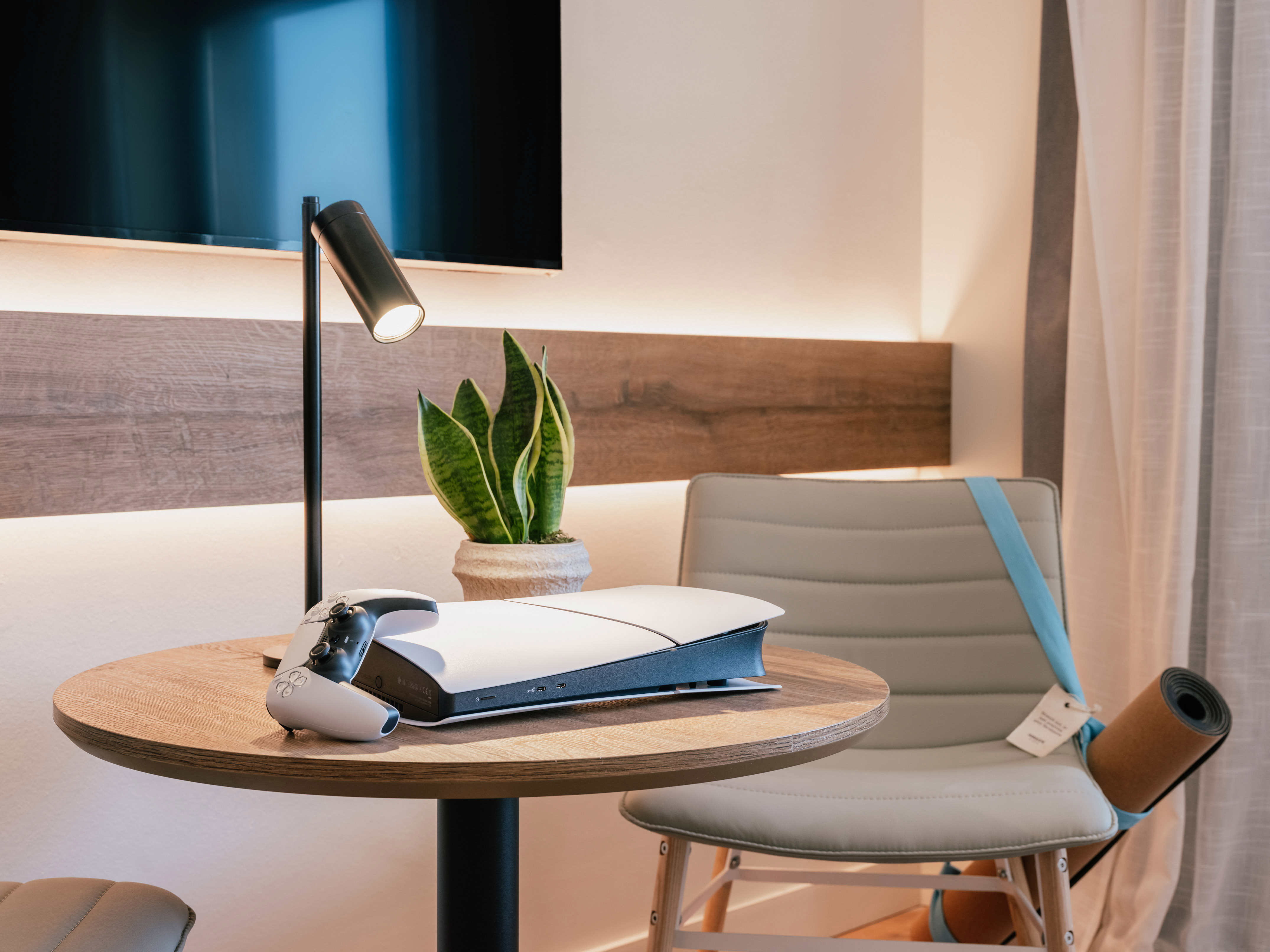 เครื่องเล่นเกม PlayStation 5 บนโต๊ะไม้กลมในห้องพักโรงแรม - The Townhouse พร้อมวิวเมือง - INNSiDE Palma Avenidas, ปัลมาเดมายอร์กา