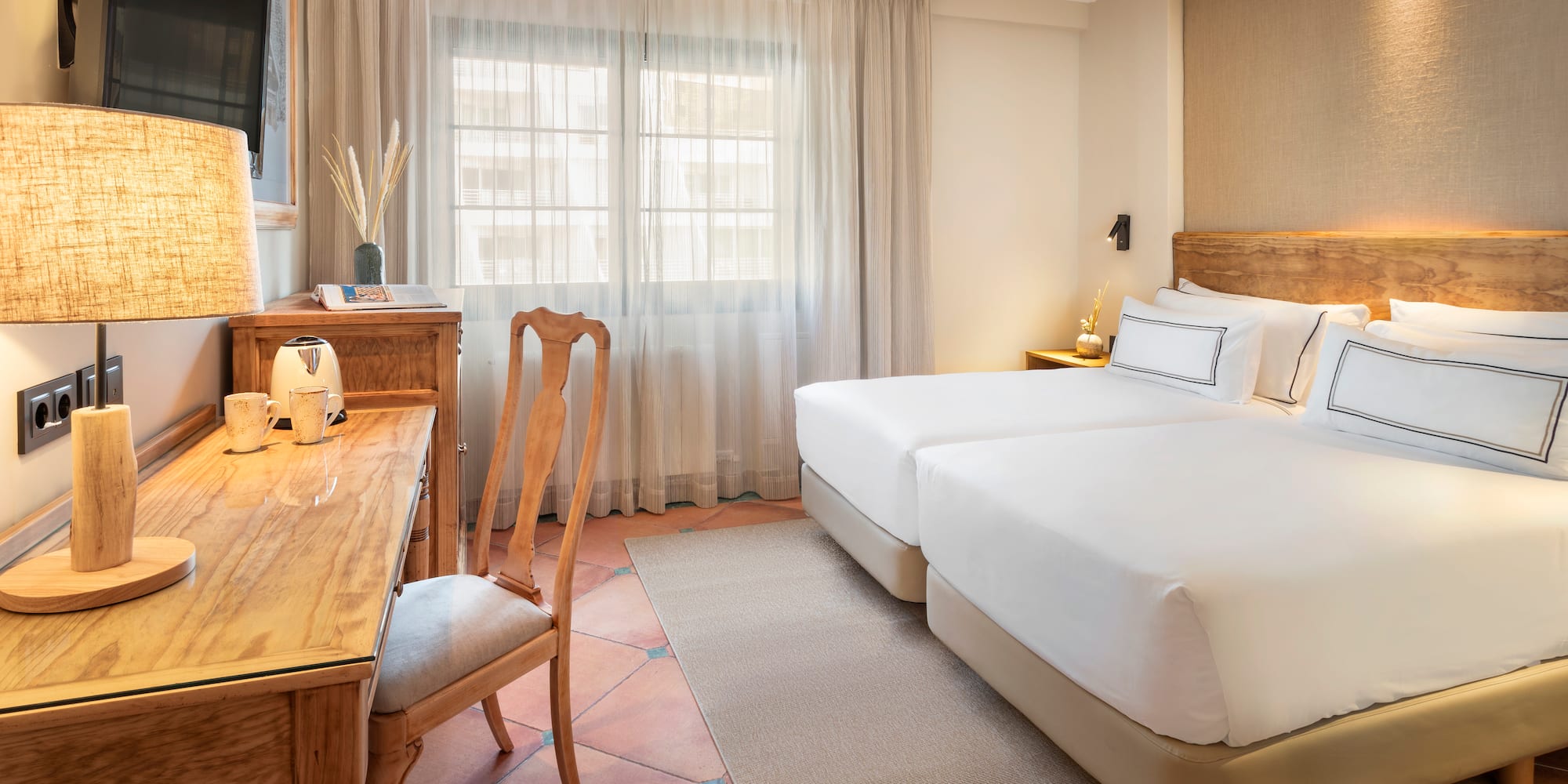 a room with two beds and a desk