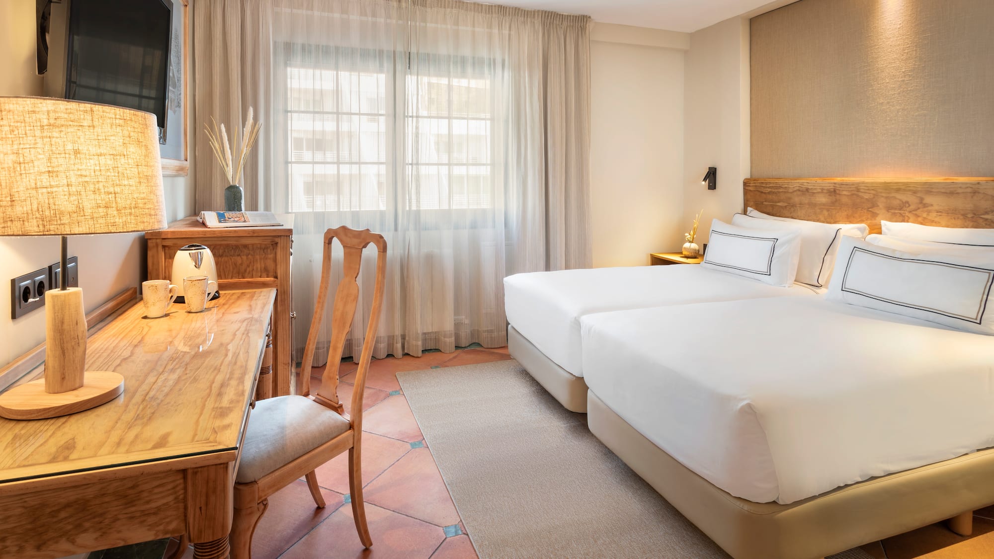 a room with two beds and a desk