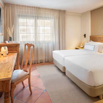 a room with two beds and a desk