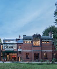 a large brick building with trees in the background