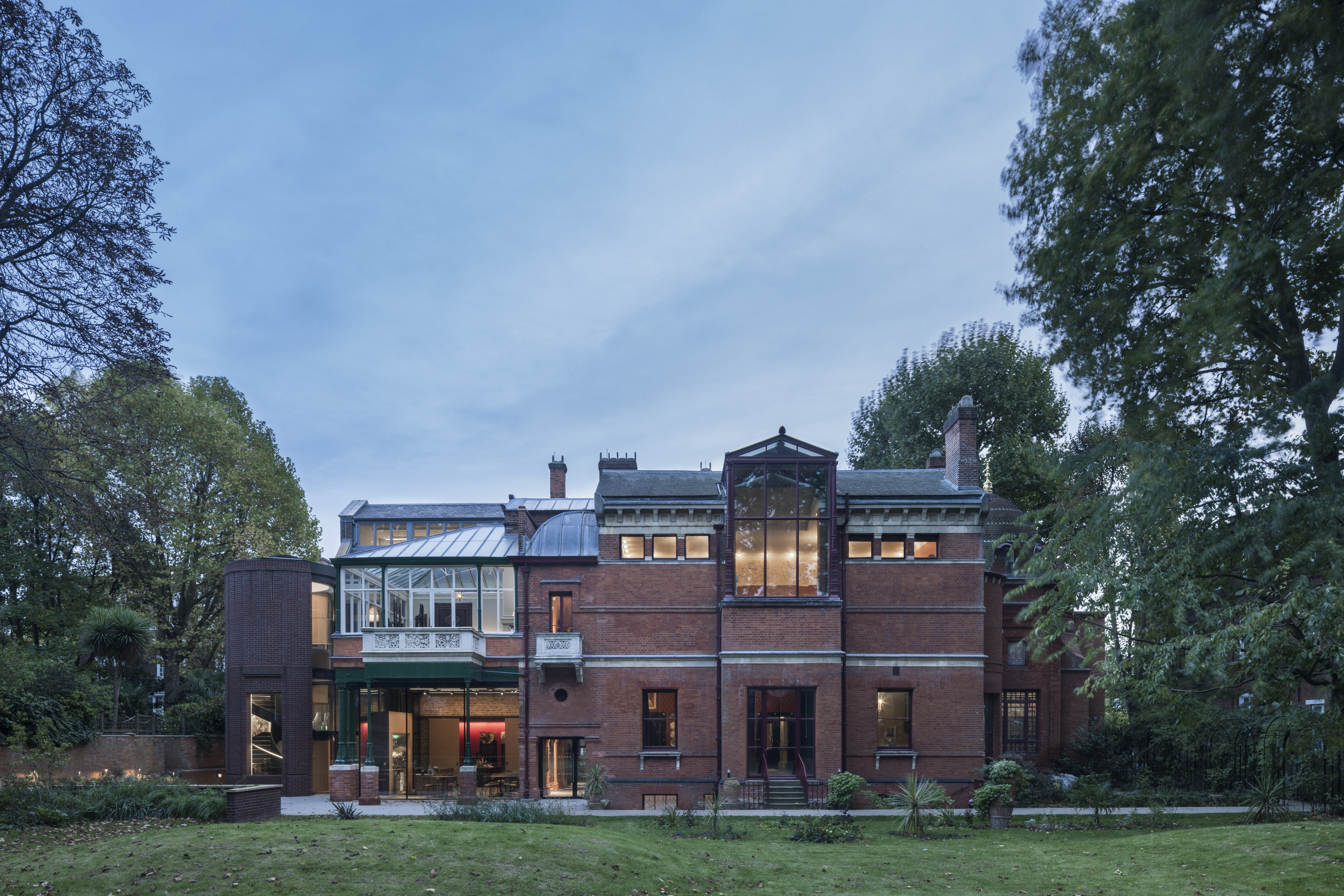a large brick building with trees in the background