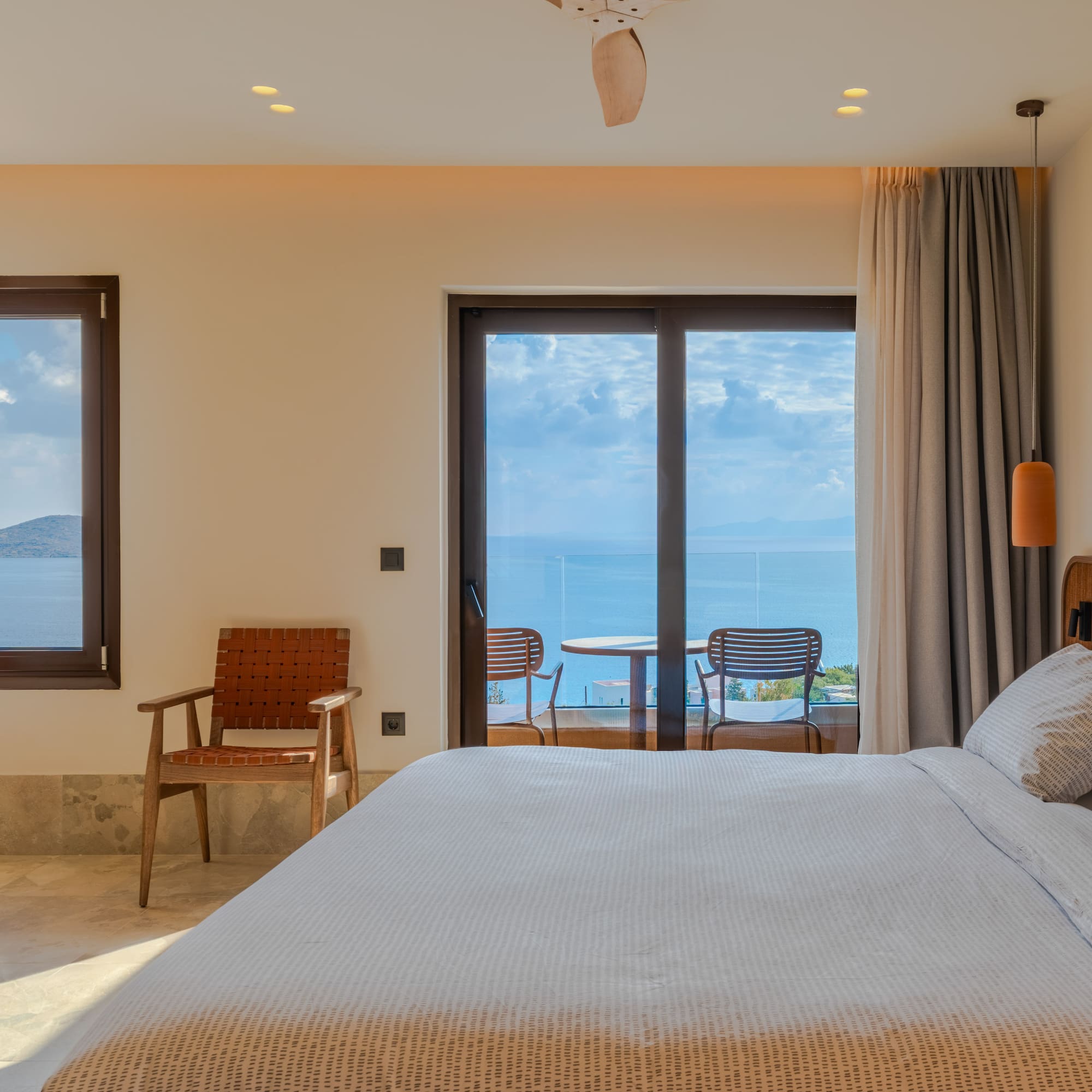 a bedroom with a bed and chairs and a table with chairs