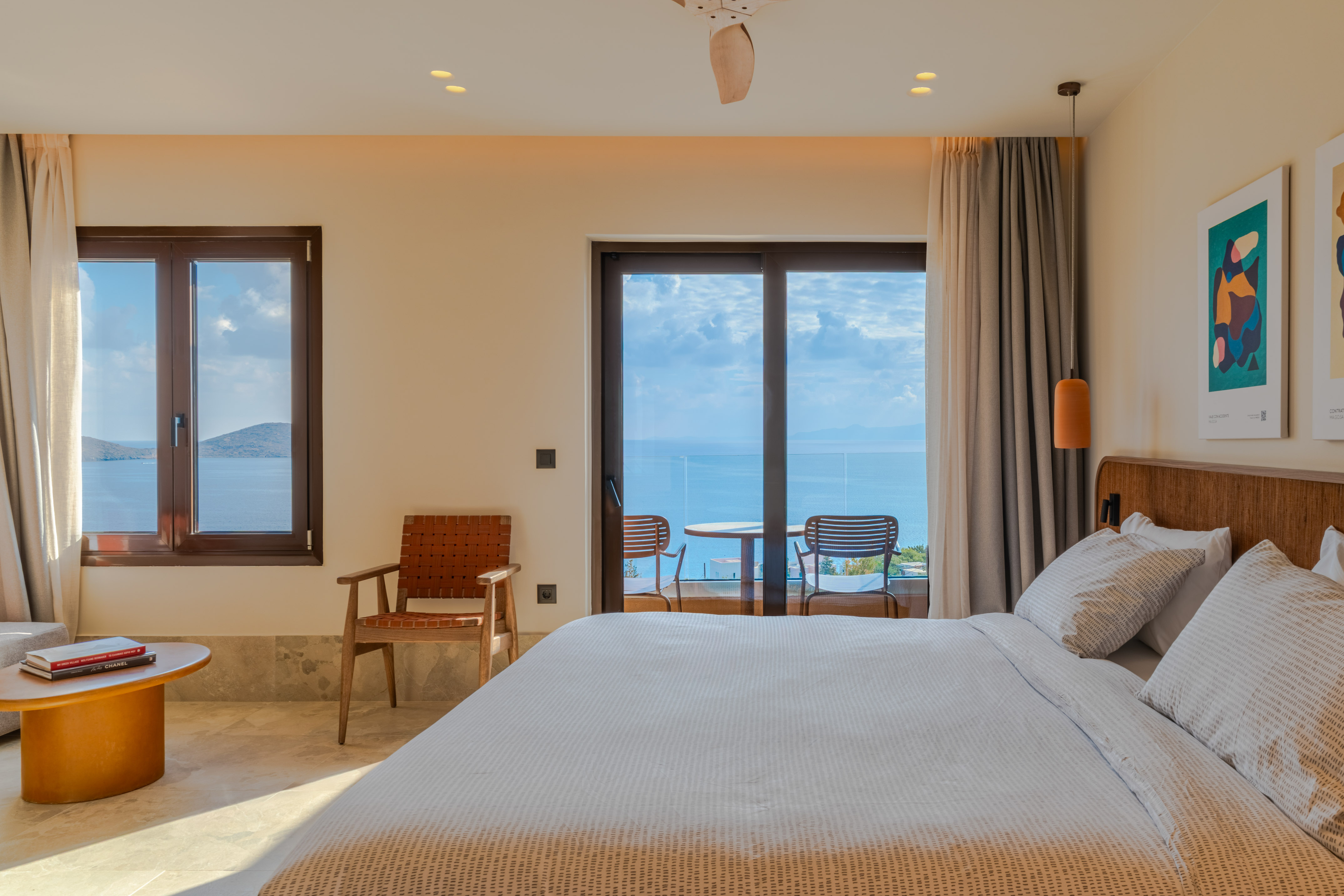 Modern hotel bedroom with sea view balcony and contemporary design.