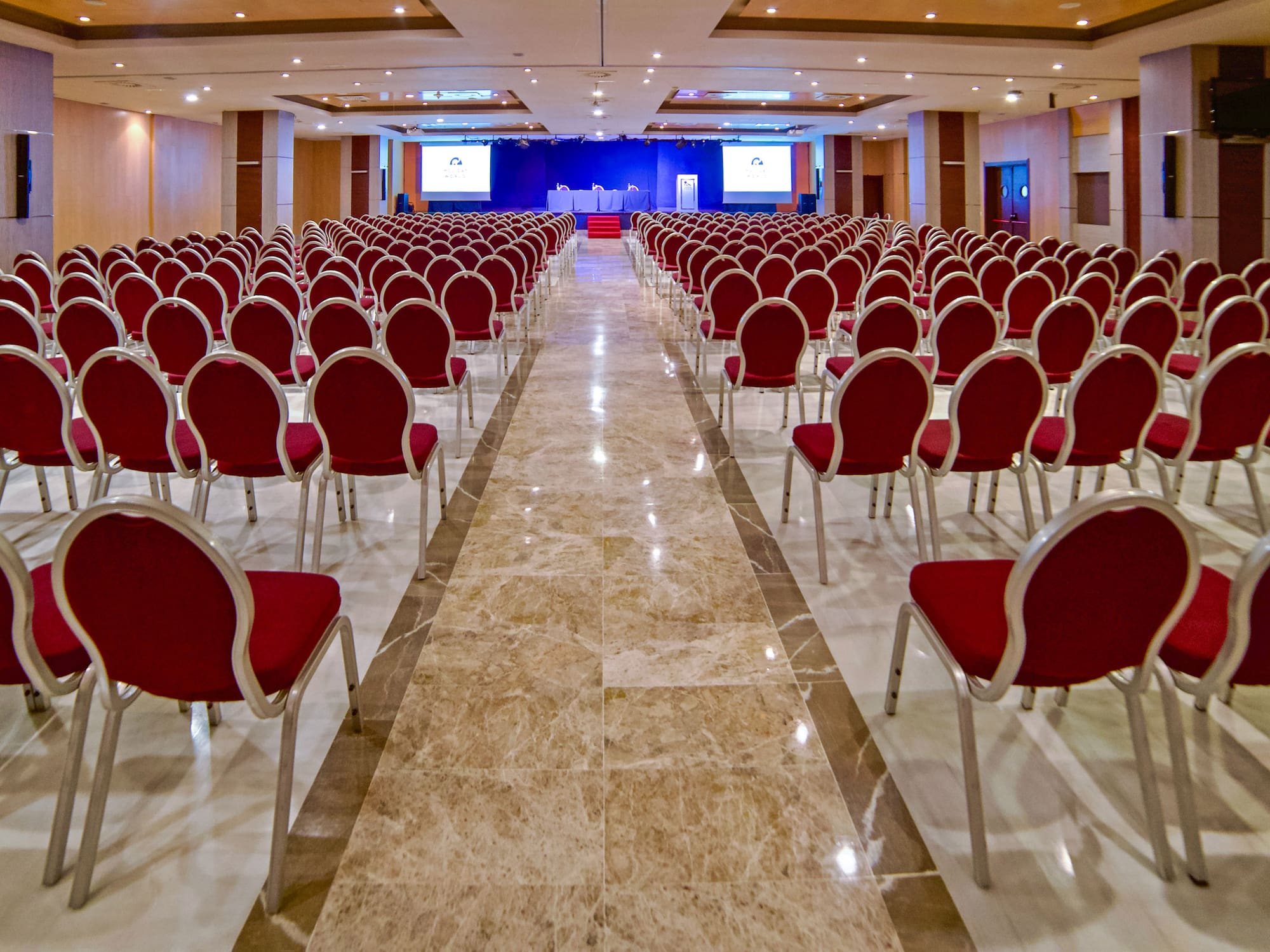 a room with red chairs and a stage