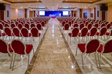 a room with red chairs and a stage
