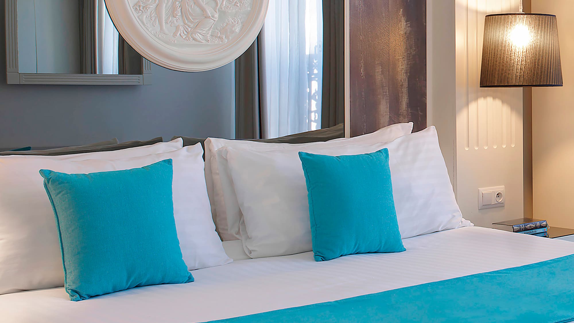 a bed with blue pillows and a white bed spread