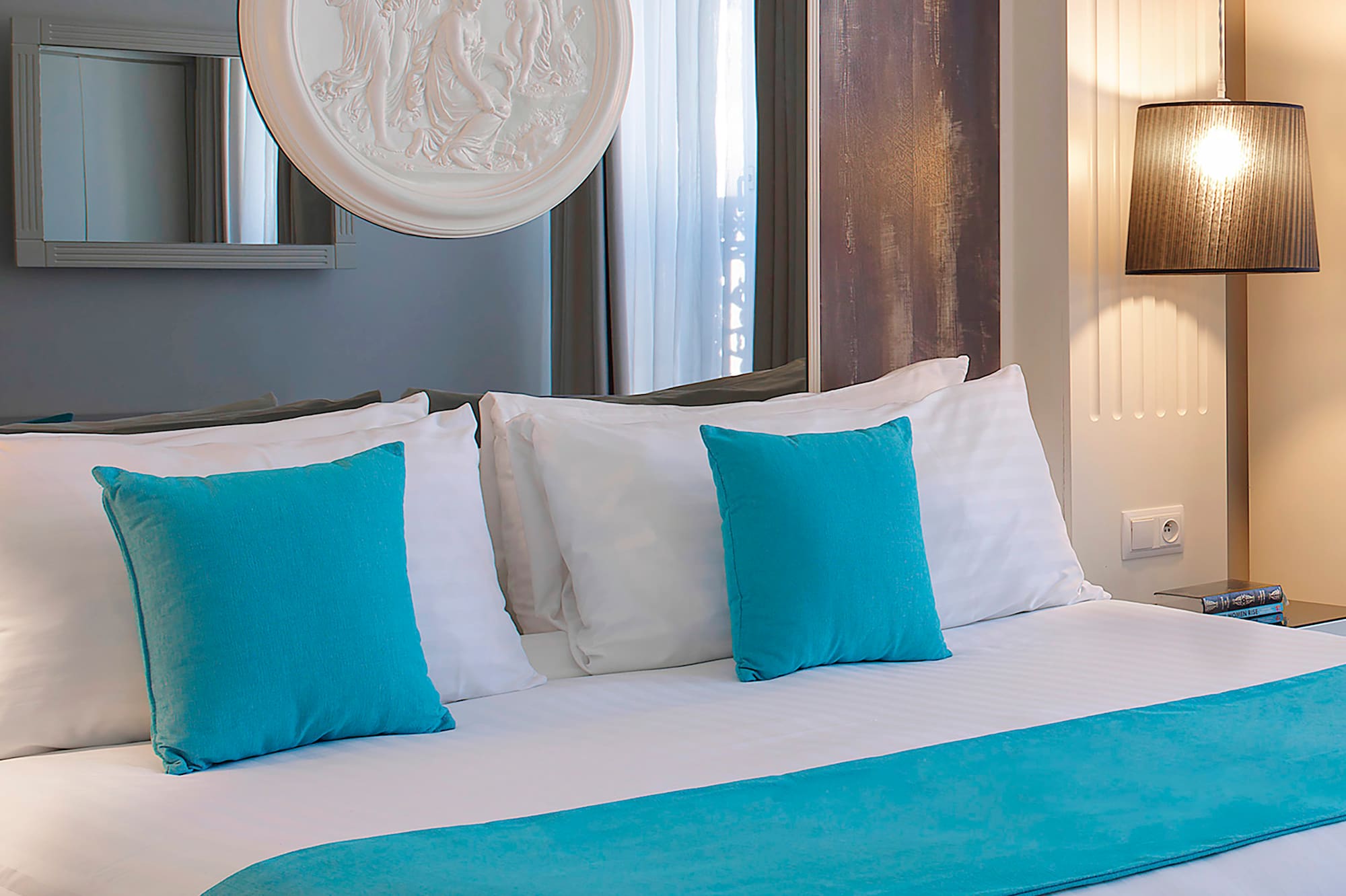 a bed with blue pillows and a white bed spread