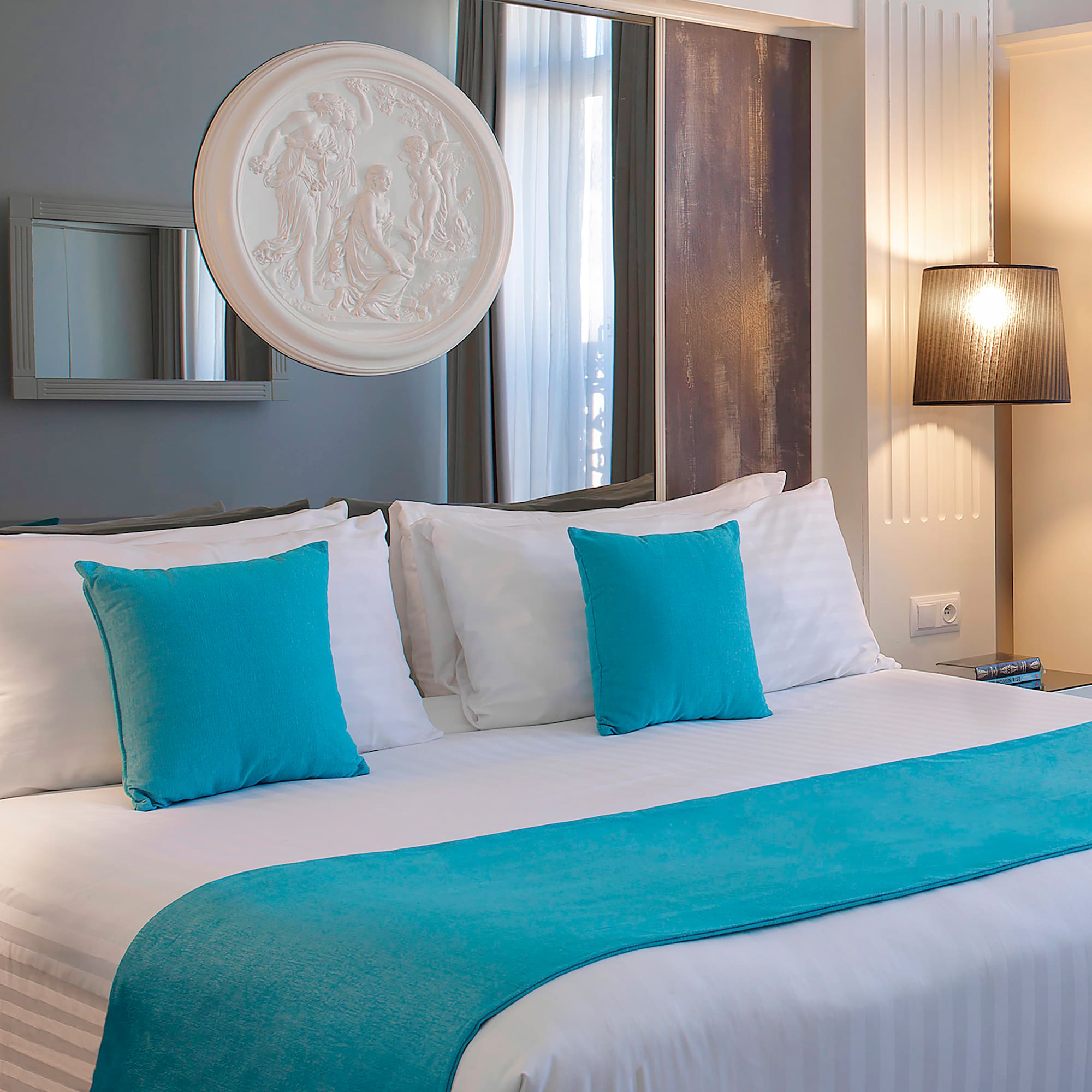 a bed with blue pillows and a white bed spread