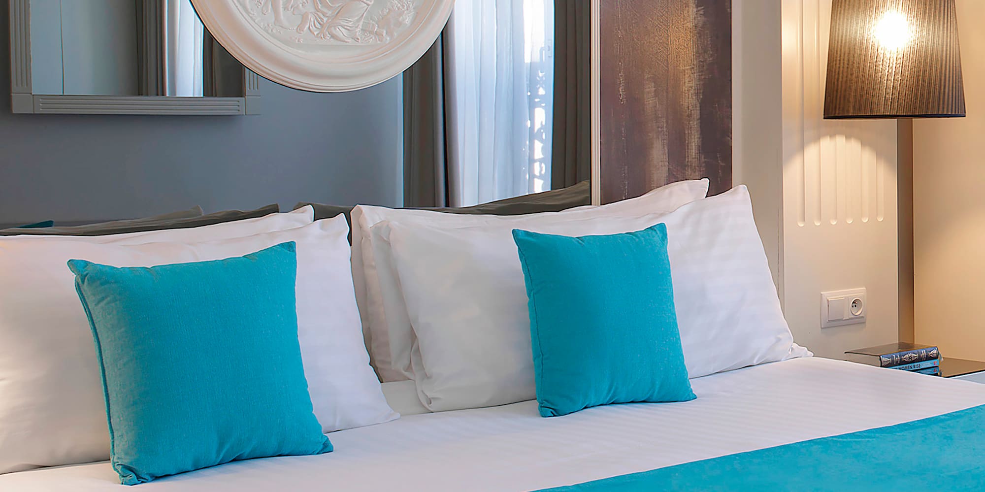 a bed with blue pillows and a white bed spread
