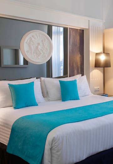 a bed with blue pillows and a white bed spread