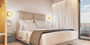 a bed with white sheets and pillows